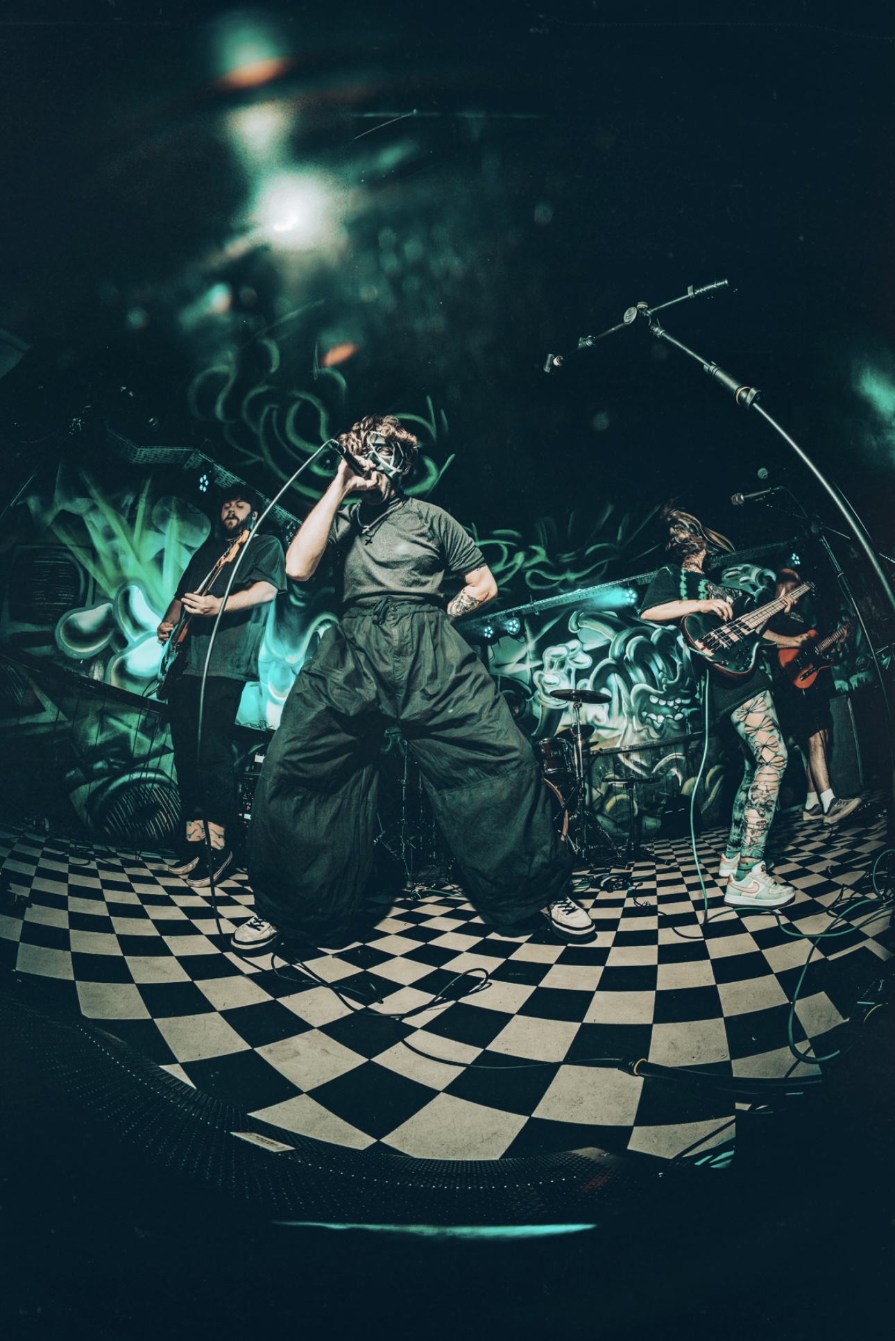 Dead Villains live performance photo — vocalist center stage on a checkerboard floor