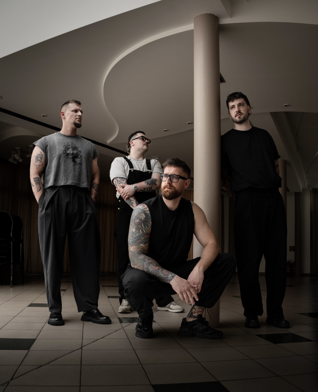 The four members of Slovak modern metal band Stercore posing inside a modern interior