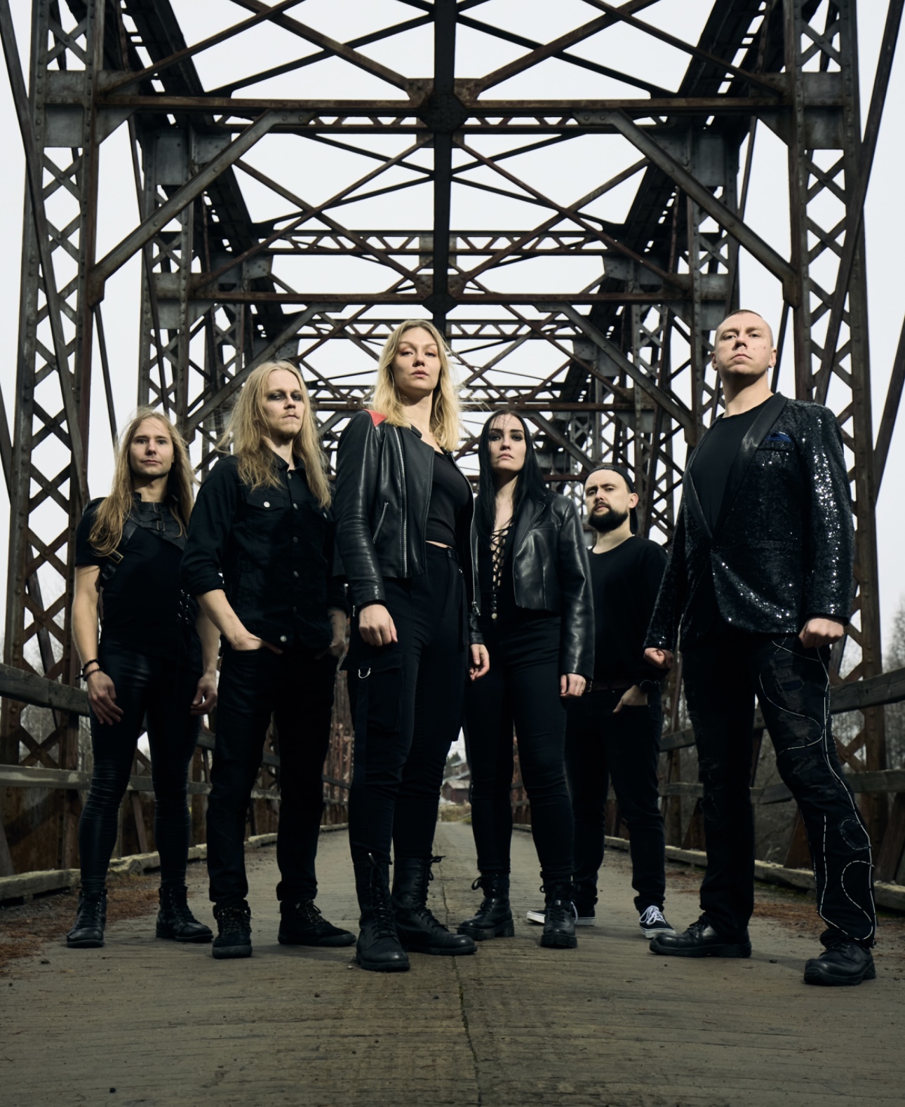 The six members of Finnish cinematic progressive metal band EGRES standing on an industrial steel bridge
