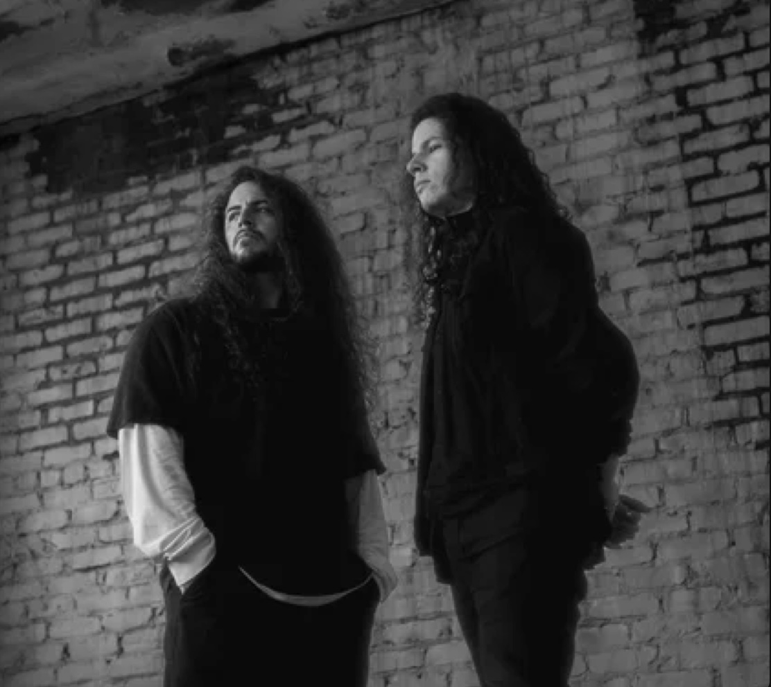 Breakthrough Even — Atlanta twin brothers photographed in black and white against a weathered brick wall
