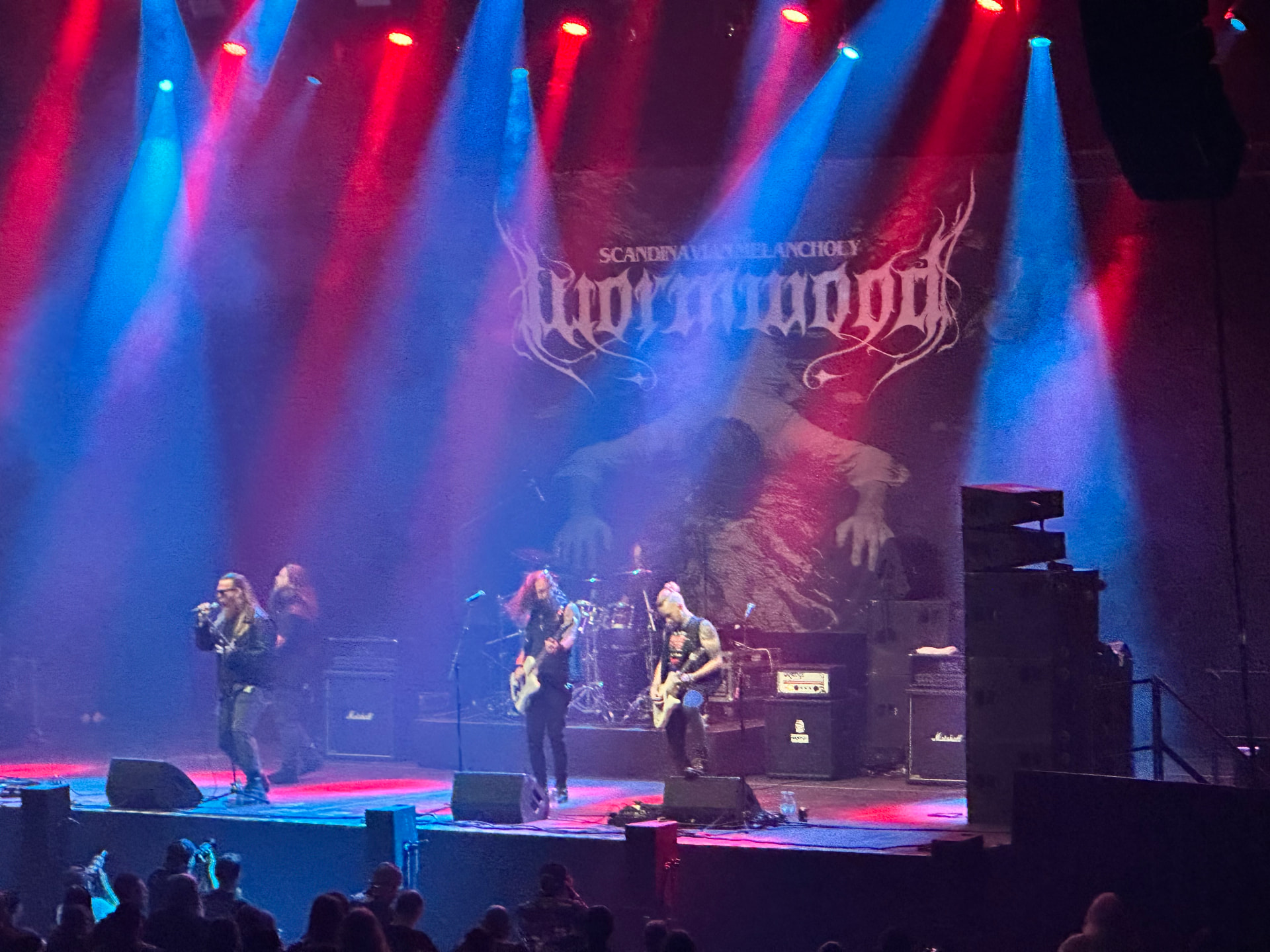 Wormwood performing at Hellsinki Metal Festival 2026 in red and blue stage light with their Scandinavian Melancholy backdrop