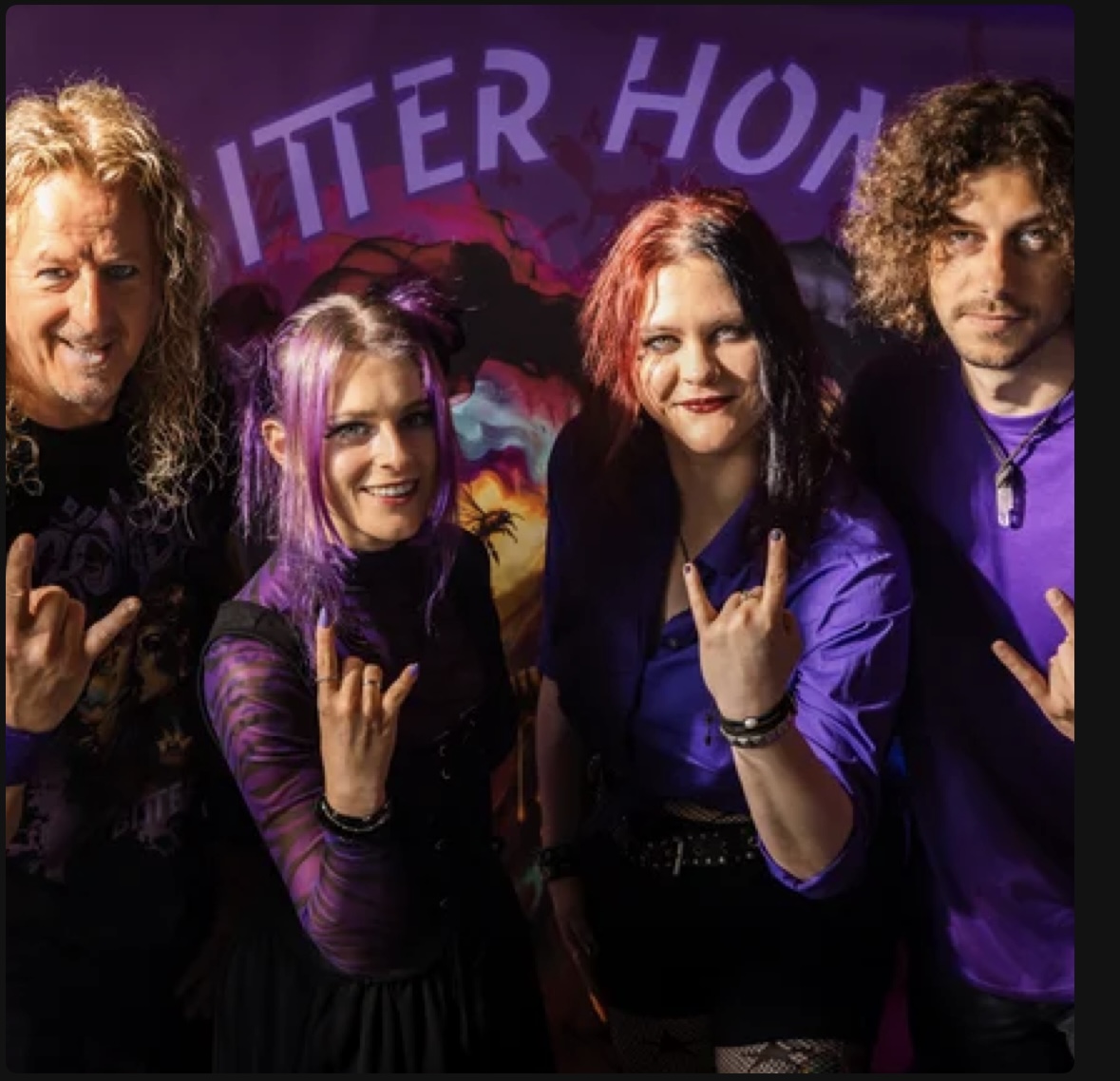 ZOMBEE band members throwing horns in front of a purple backdrop