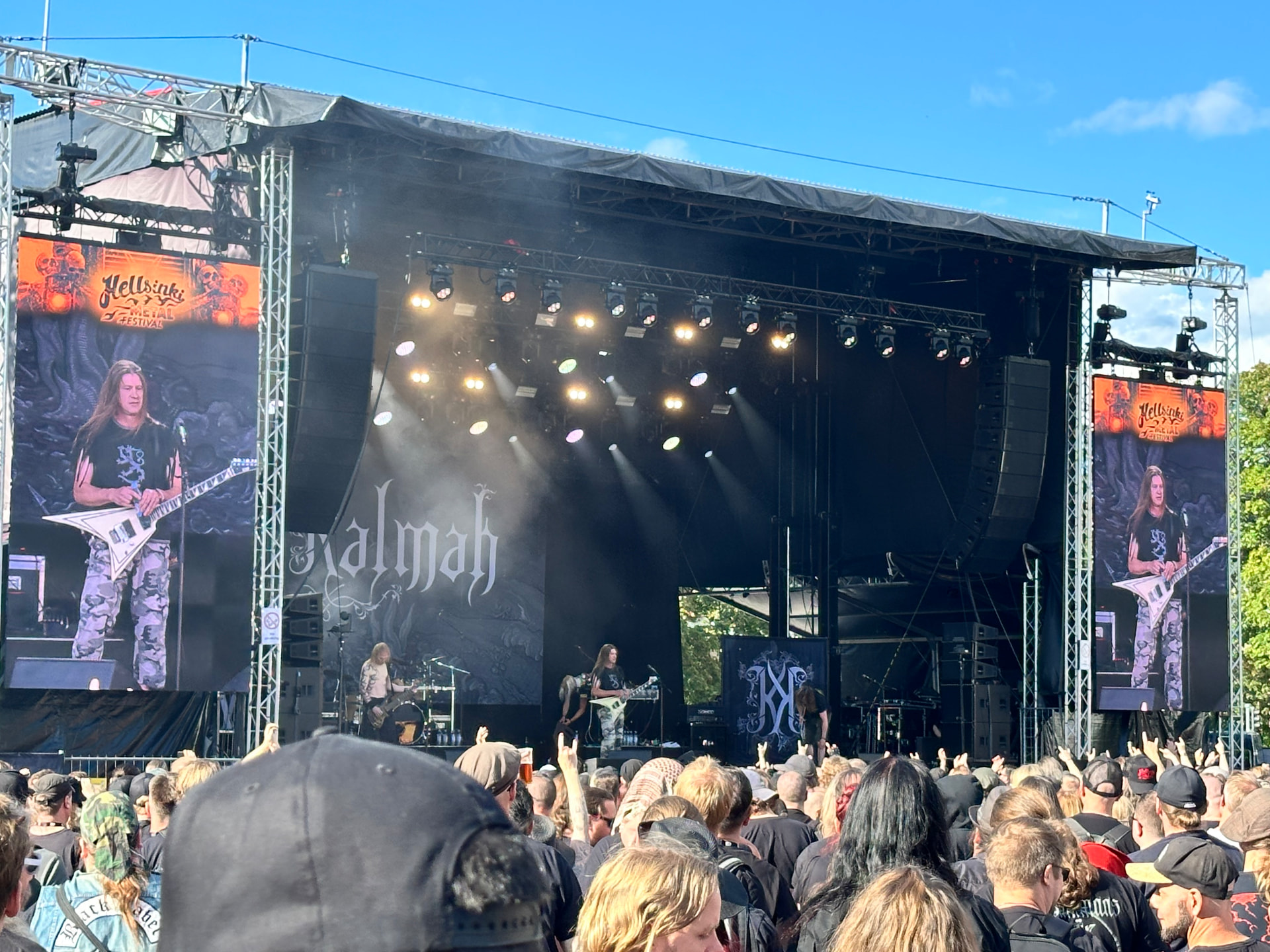 Kalmah performing on the main stage at Hellsinki Metal Festival 2026 in bright evening sunlight with a packed crowd