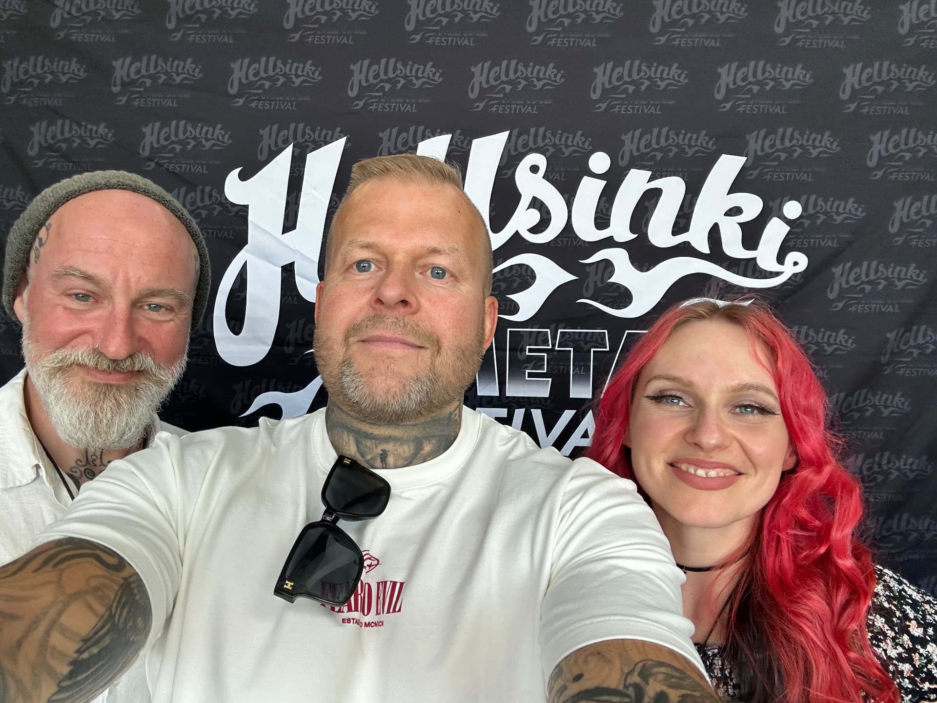 Tomi Perrakoski backstage with members of Eluveitie in front of the Hellsinki Metal Festival 2026 backdrop