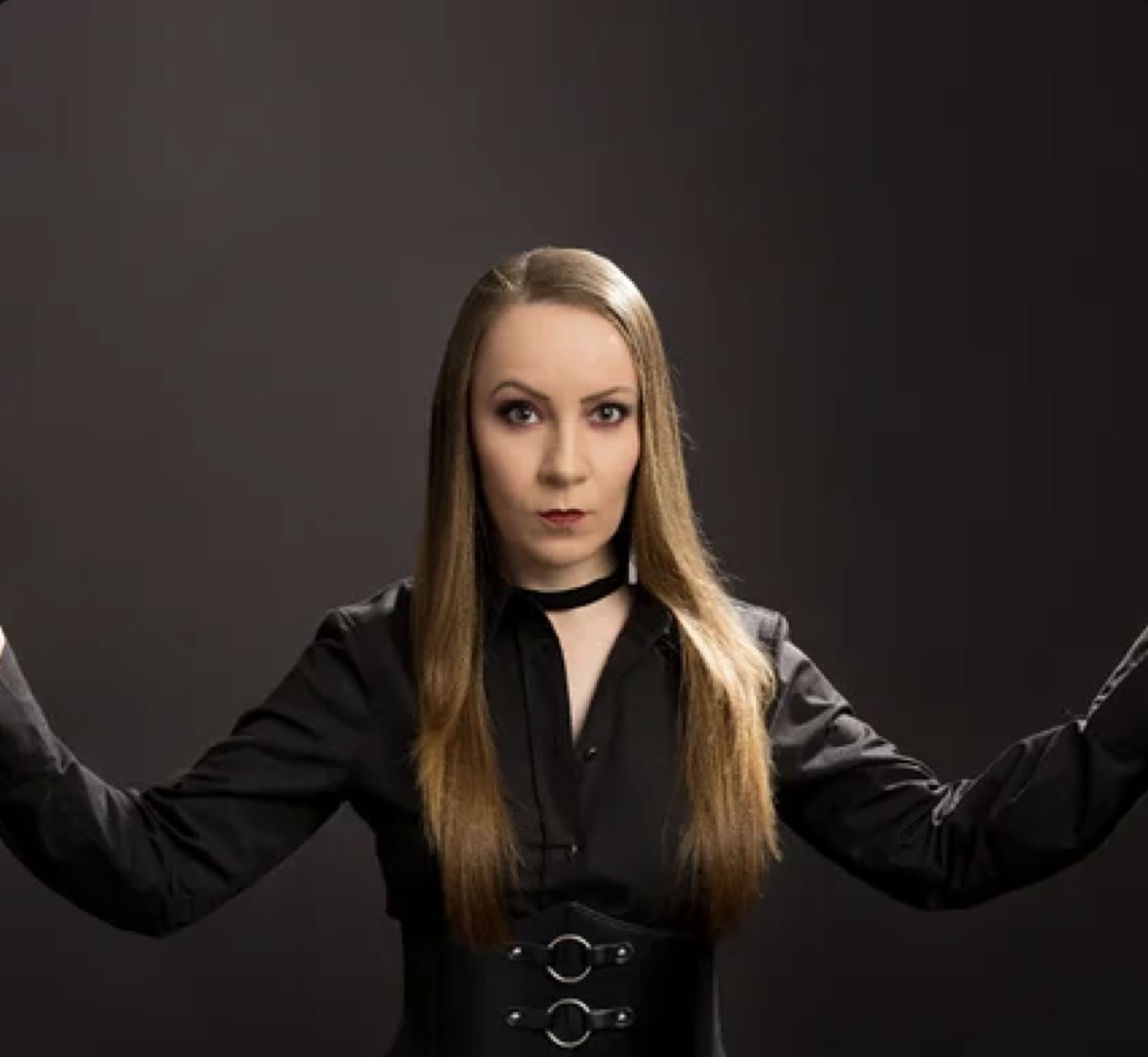 Brazilian singer Daniela Moreira in a black outfit against a dark background
