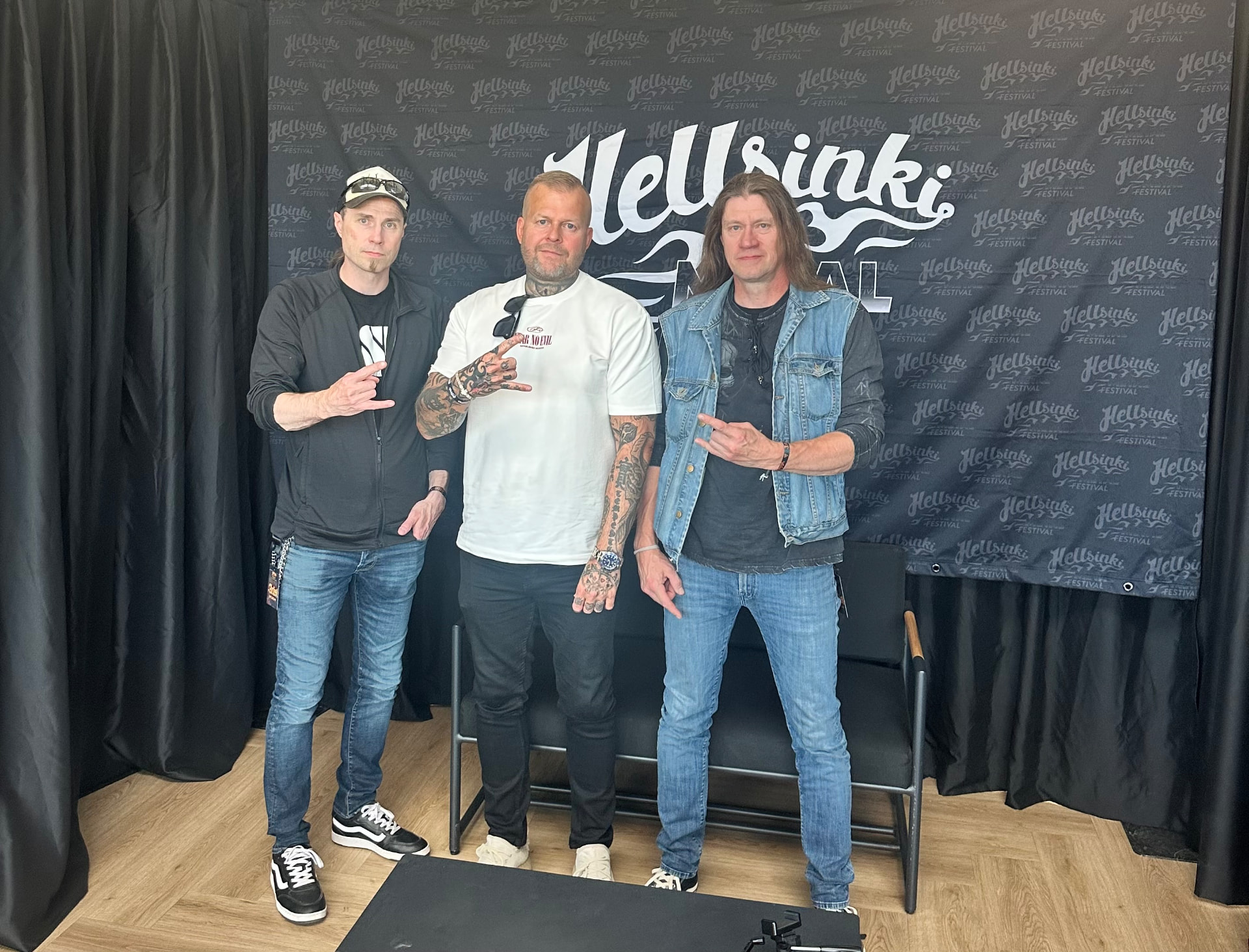 Tomi Perrakoski backstage with members of Kalmah in front of the Hellsinki Metal Festival 2026 backdrop